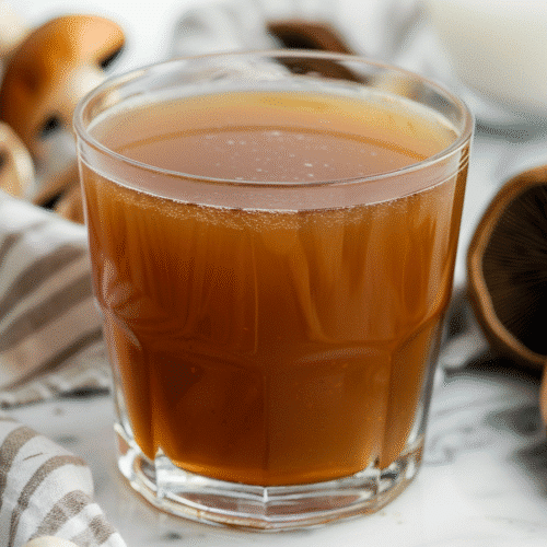 How To Make Immune-Boosting Mushroom Broth 2 Homemade Mushroom Broth in Glass Jar on Marble Surface